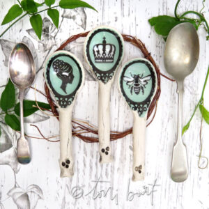 trio of handmade ceramic spoons with queen and bee imagery